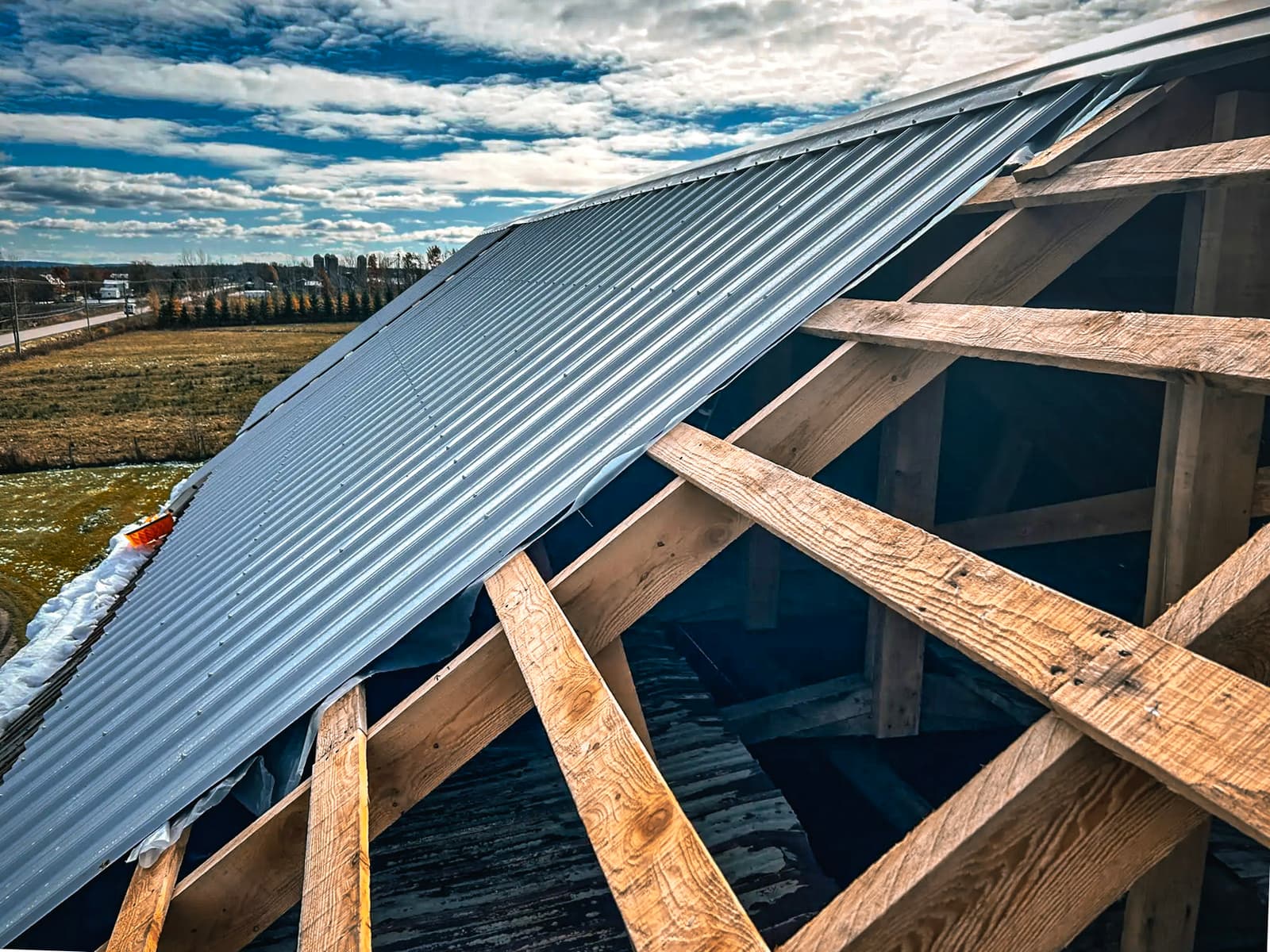 Metal roof installation on a wooden framework.