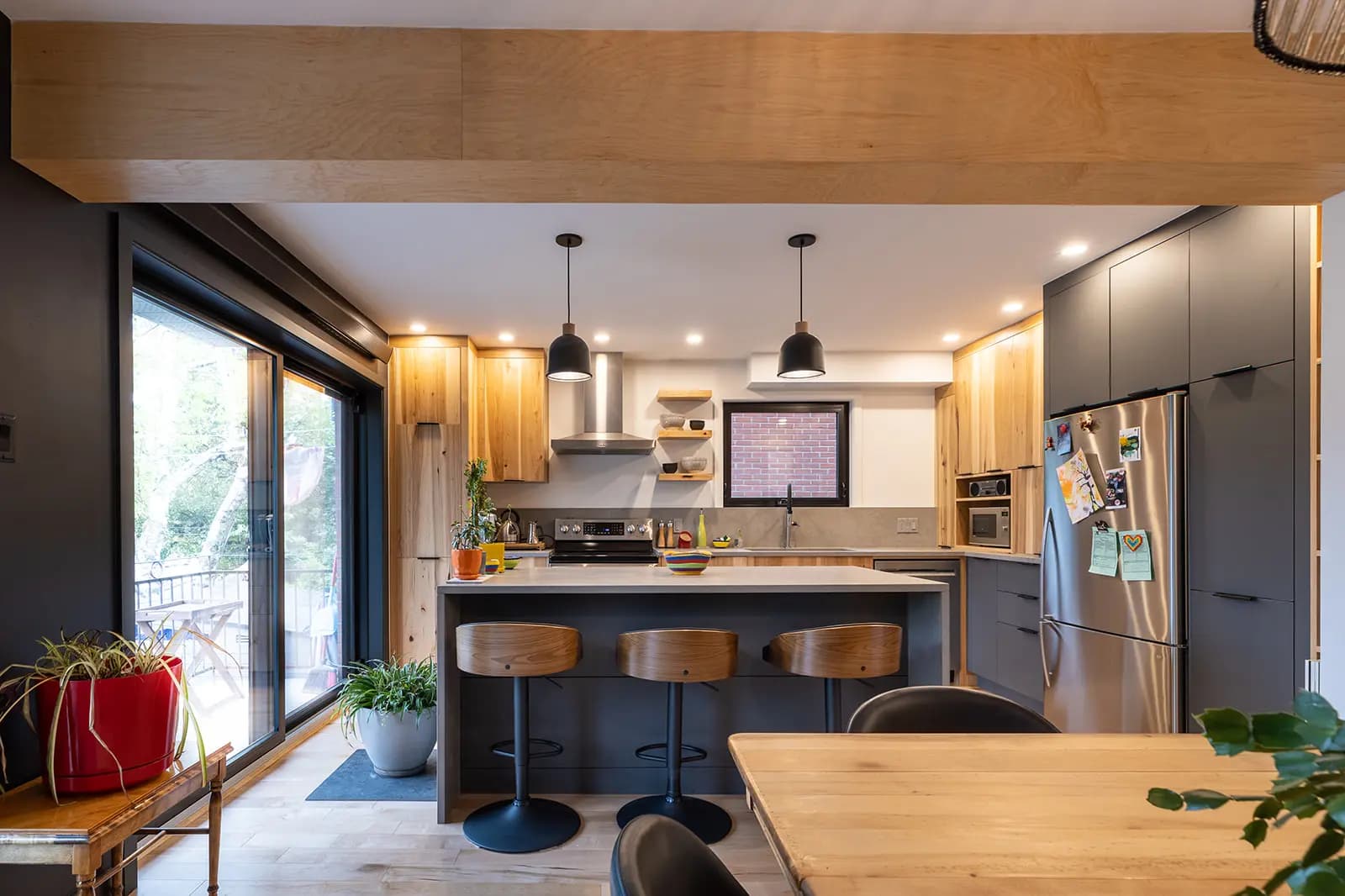 Scandinavian-inspired kitchen with industrial hints. The pairing of light-hued wood and charcoal makes for an elegant and modern contrast. The central island is perfect for meals with family or friends