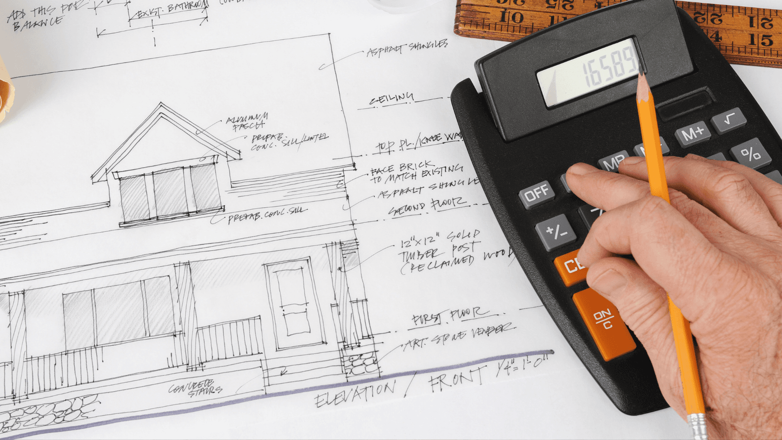 A detailed architectural plan of a house is spread out on a table, with annotations and measurements. A hand holding a pencil rests on a calculator, suggesting the calculation of project costs