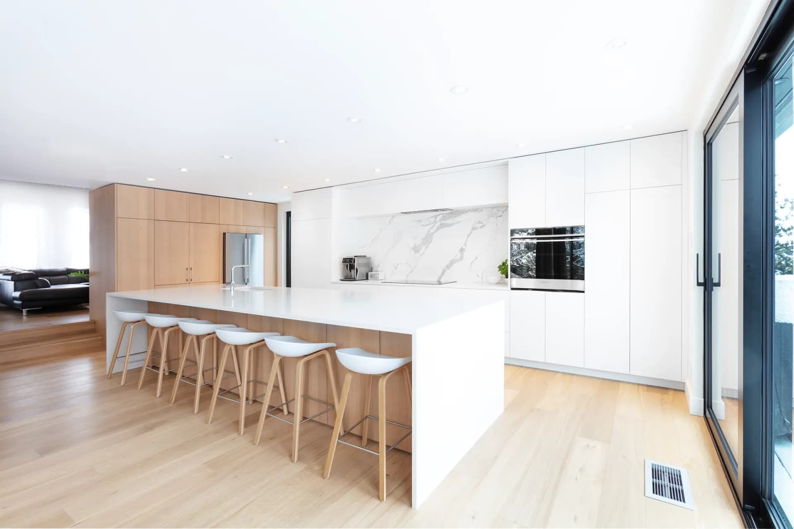 Scandi kitchen with a contemporary twist. The pairing of light wood, white, and marble makes with a cozy yet sleek look. The kitchen island is perfect for meals with family or friends.