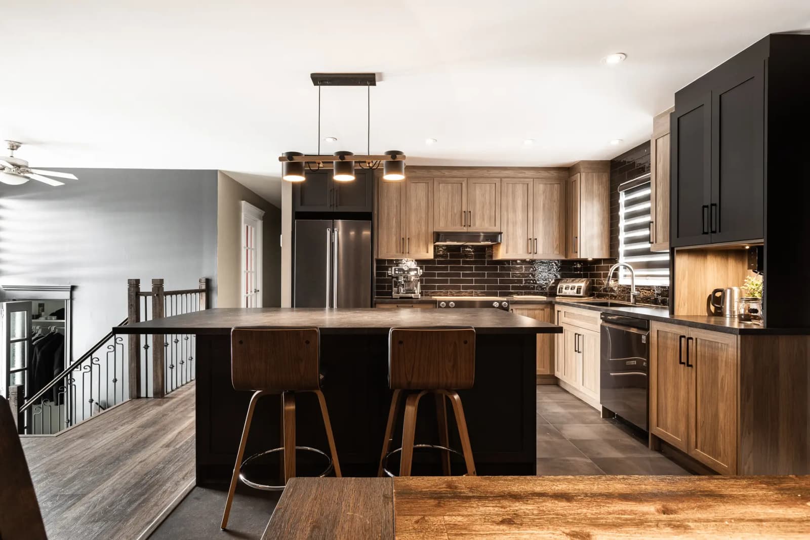 Design idea: cozy industrial kitchen. Pairing dark wood, black, and hints of metal makes for a masculine and sophisticated aesthetic. The kitchen island is perfect for meals with family or friends.