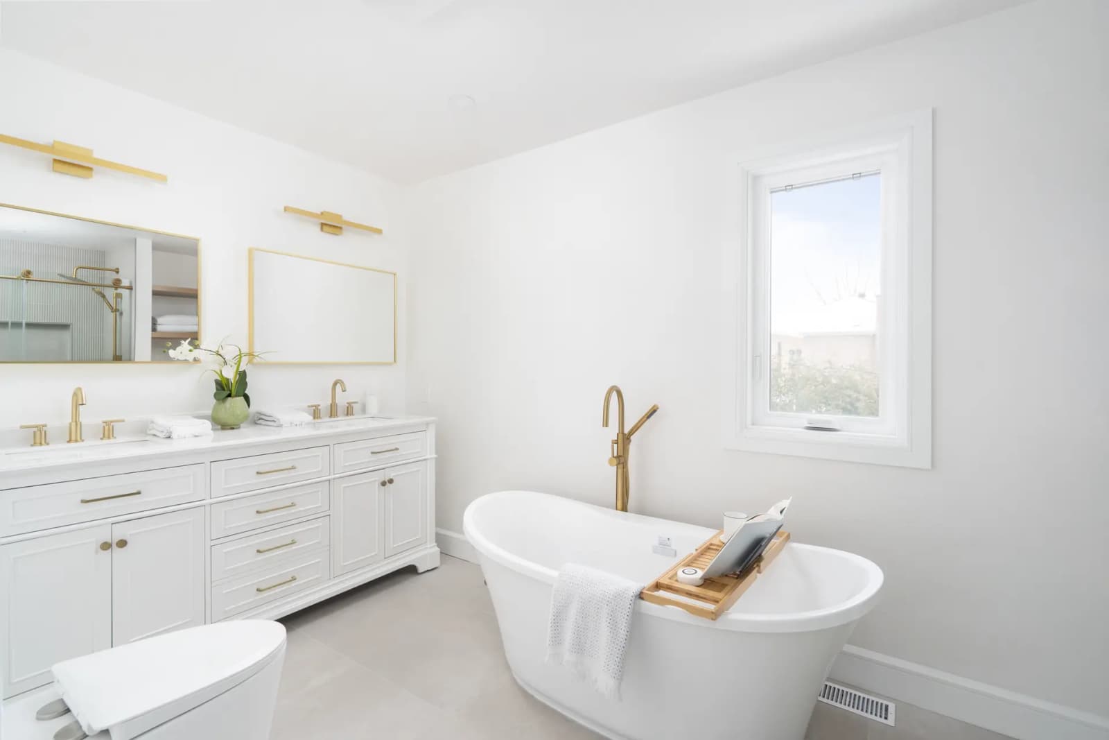 Modern and bright bathroom with a freestanding bathtub and brass finishes.