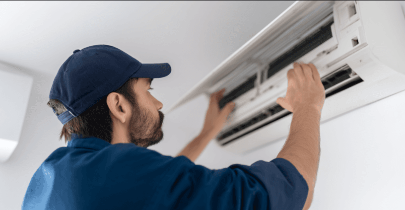 Technician repairing or installing a wall-mounted indoor air conditioner
