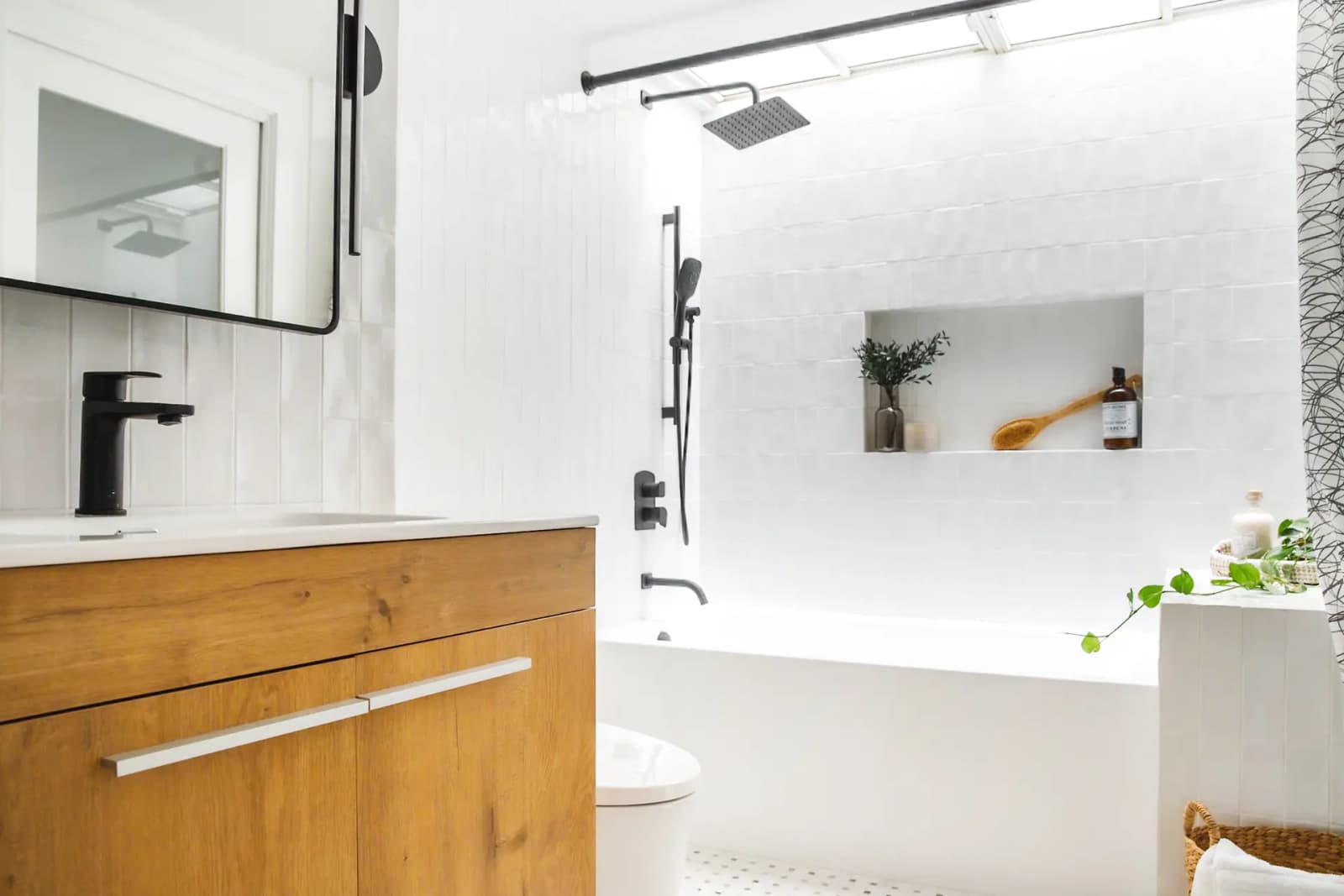 Bright bathroom with a white bathtub, a shower equipped with a rain showerhead, and a wooden under-sink vanity.
