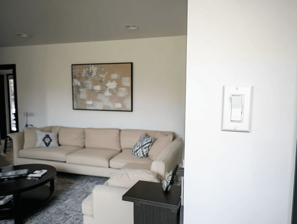 Modern living room interior with beige sofa, white wall switch, and artistic wall decor