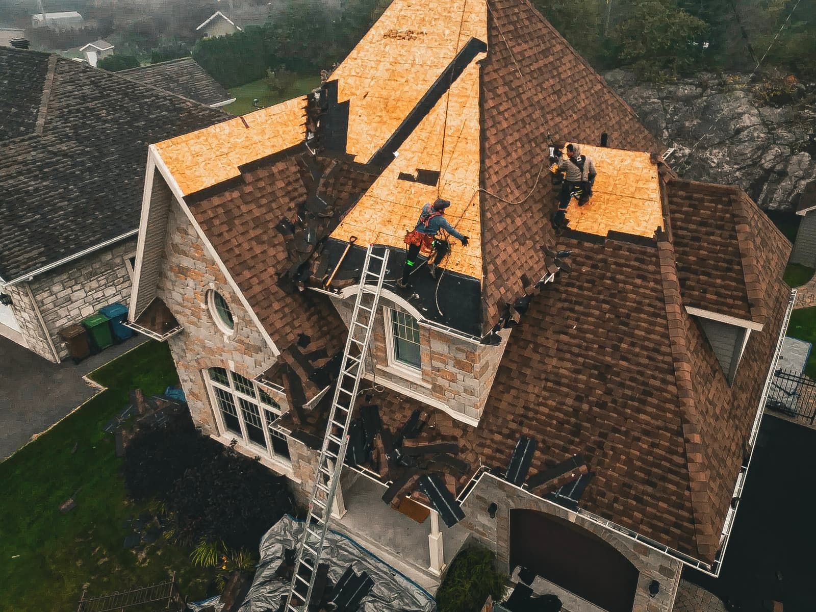 Renovation work on a residential roof with shingle replacement and new underlayment installation.