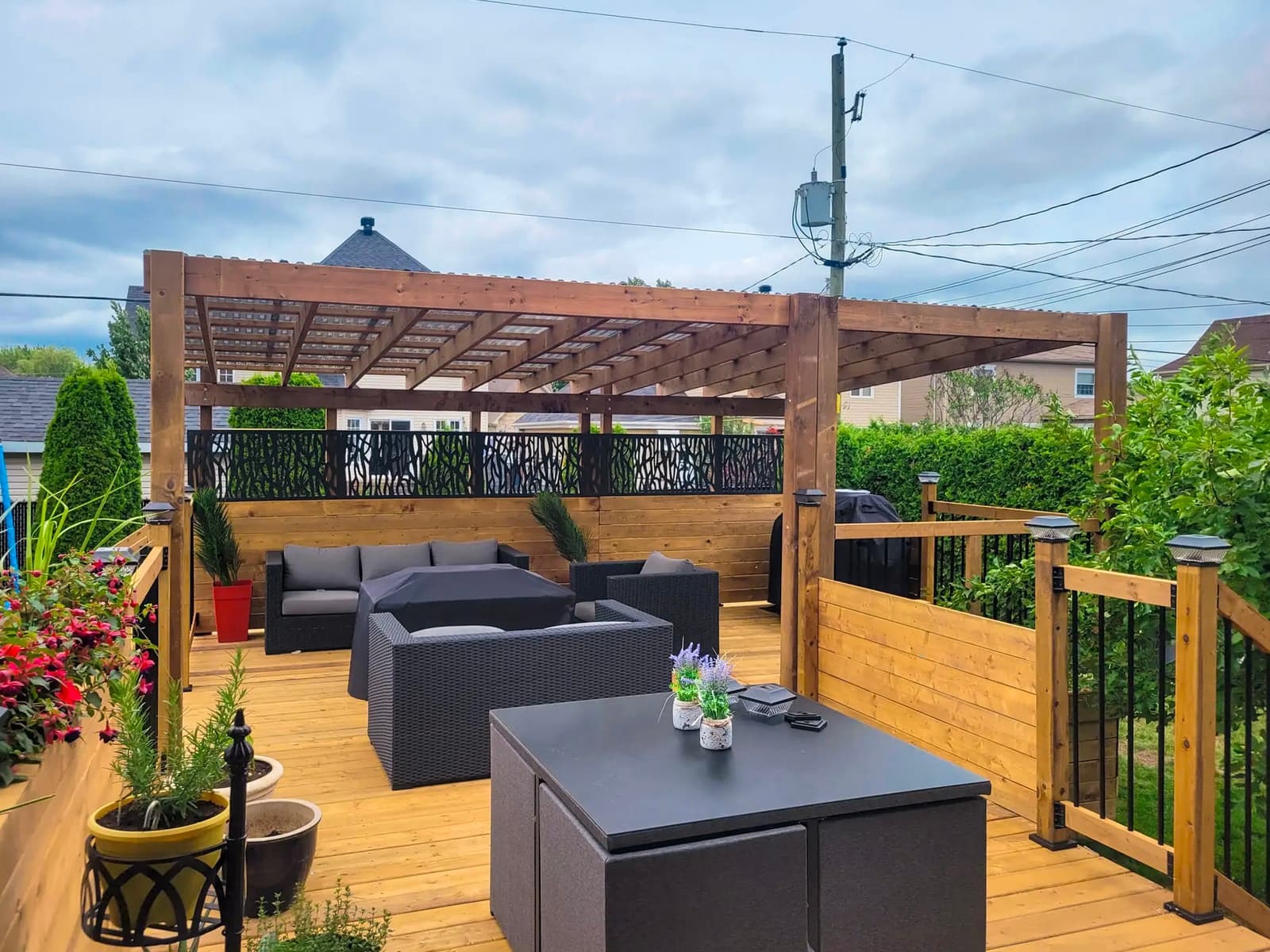 Wooden deck with wooden pergola, modern outdoor furniture, decorative metal panels, and outdoor lighting, perfect for outdoor spaces.