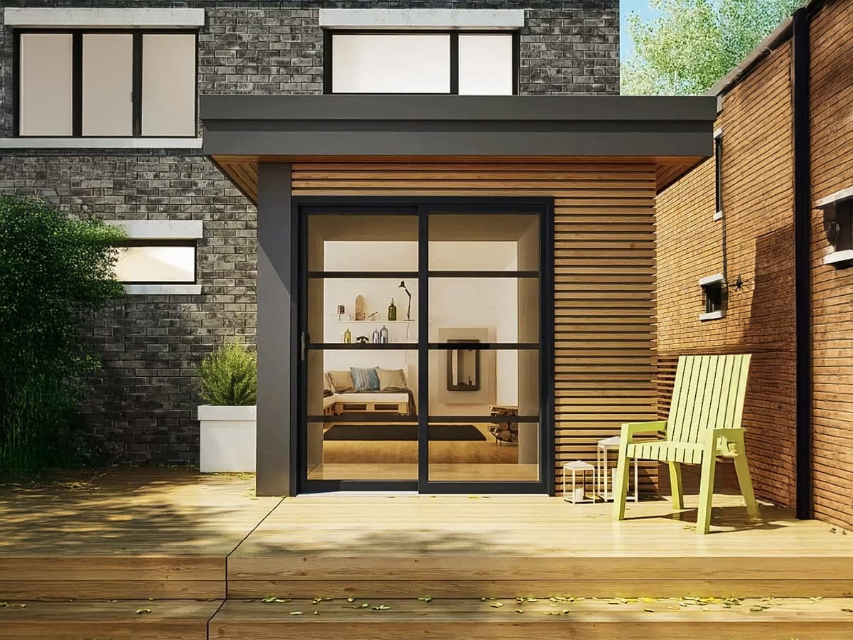 Modern facade of a contemporary house with black sliding glass door, wooden cladding, and a furnished deck.