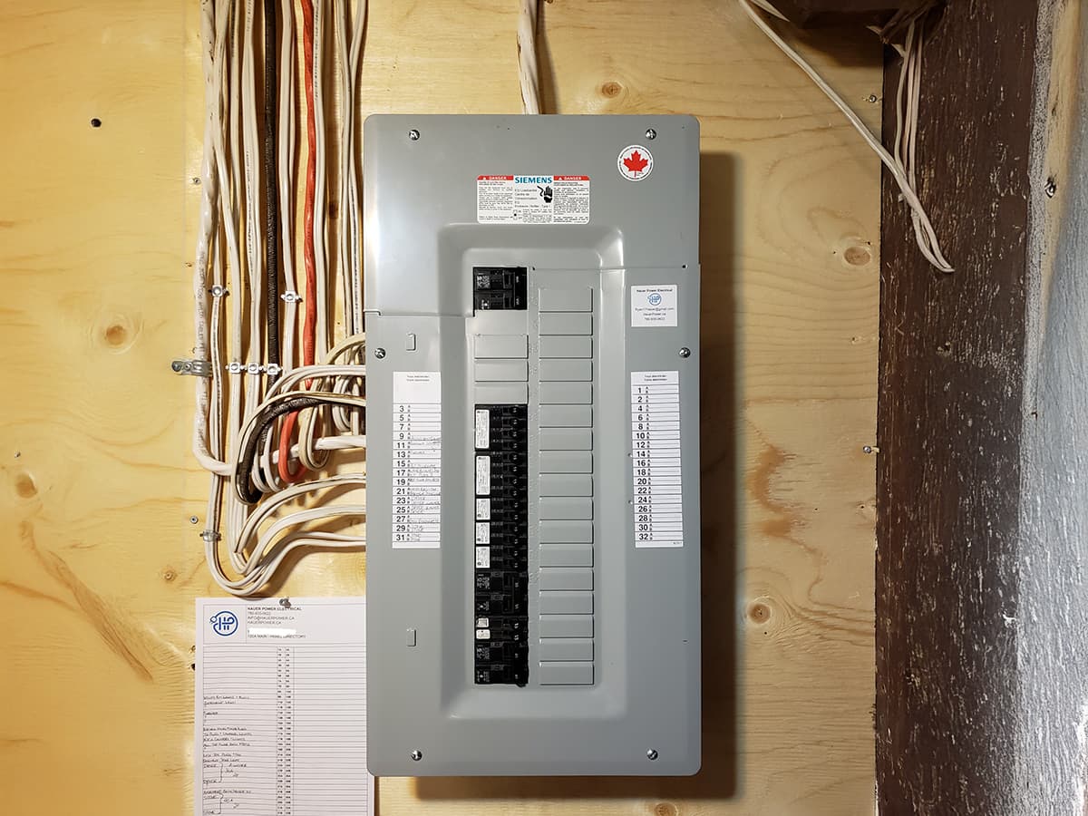 Siemens circuit breaker panel installed on a wooden board, with organized wiring for a residential electrical system.