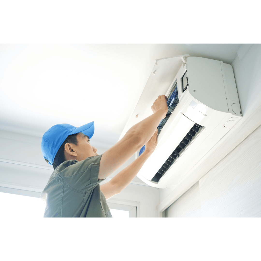 Technician performing maintenance on a wall-mounted air conditioner to ensure optimal operation.