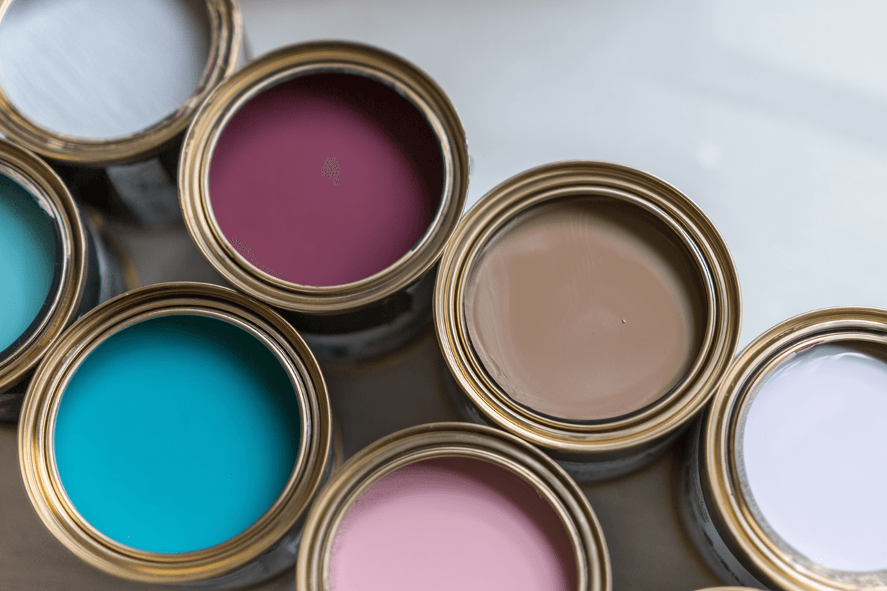 Open paint cans with various vibrant colors on a neutral background