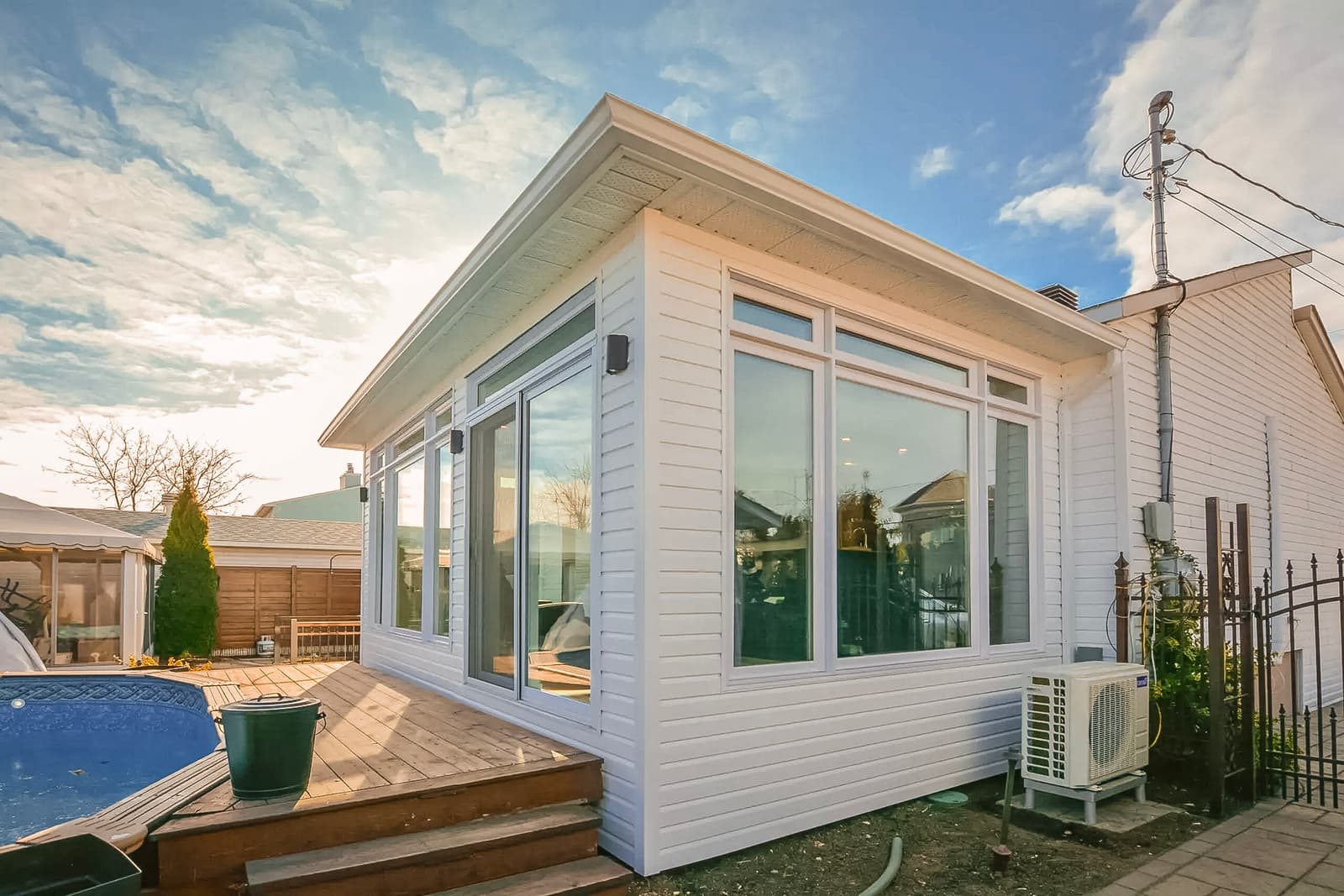Bright home extension with panoramic windows, wooden deck, and efficient insulation.