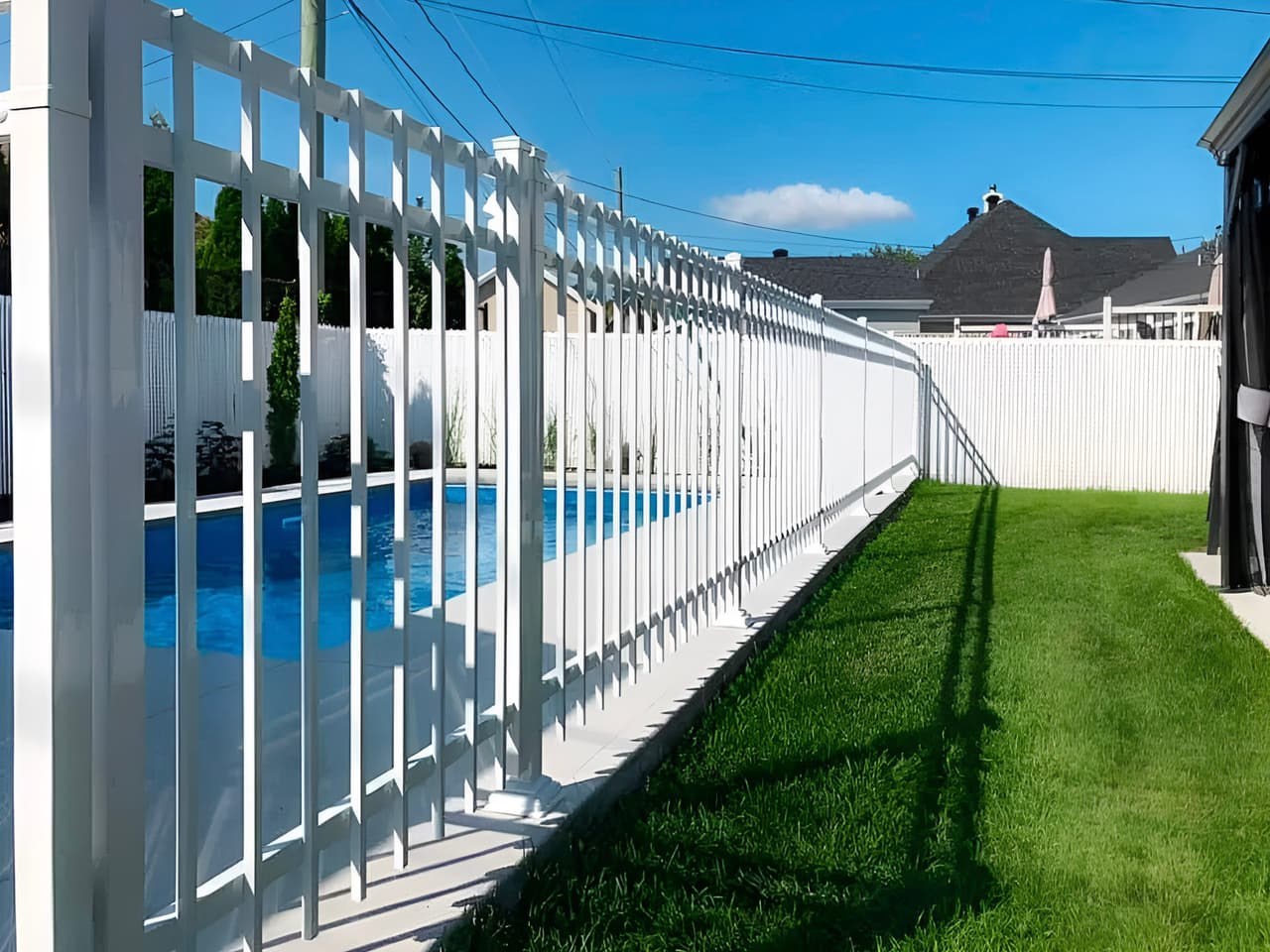 White safety fence surrounding a residential backyard swimming pool
