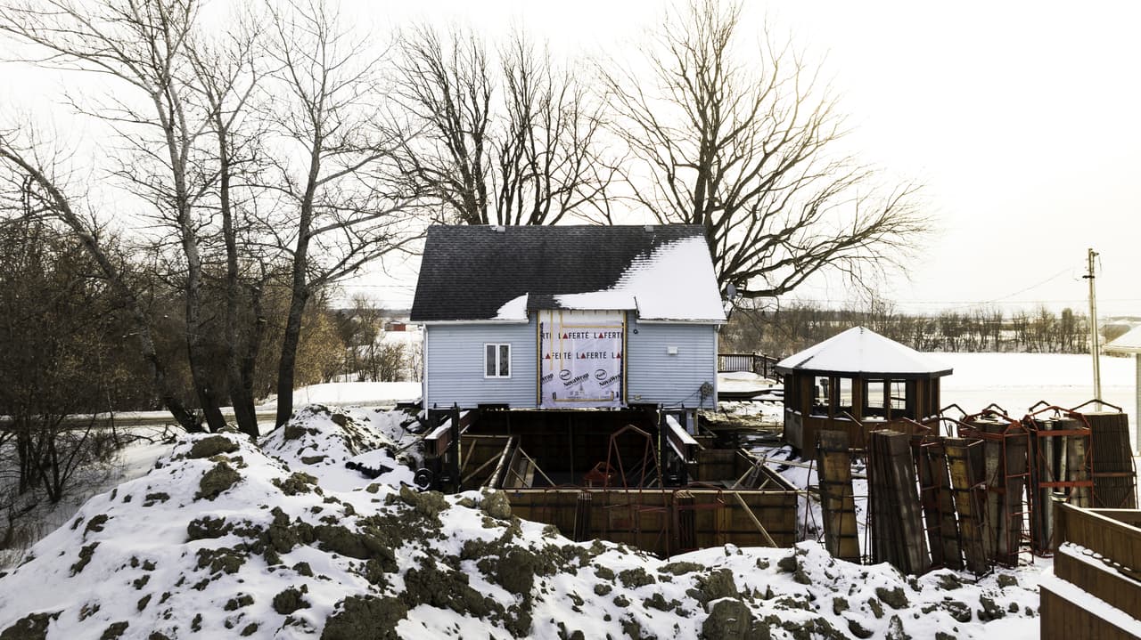 Raised house with formwork and foundation work in winter in a snowy rural environment for extension