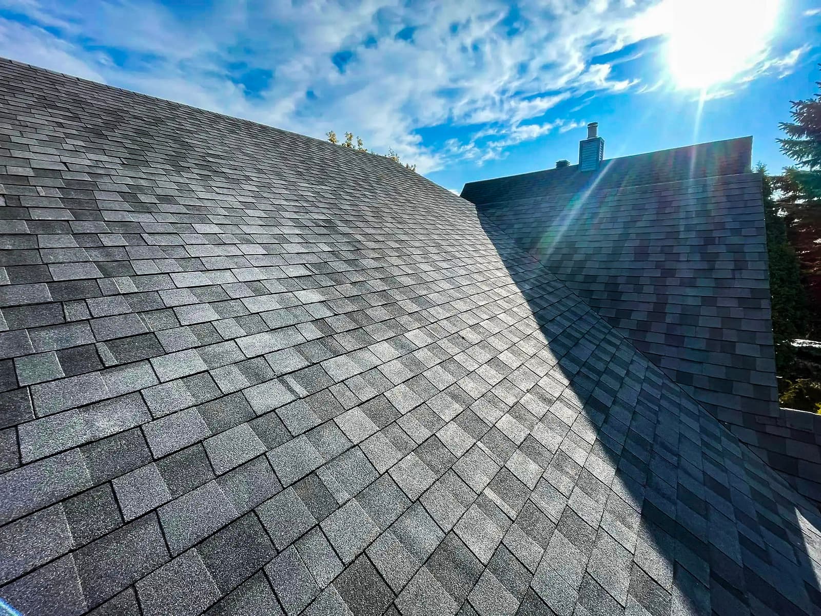 Modern shingle roof with natural lighting under a sunny sky.