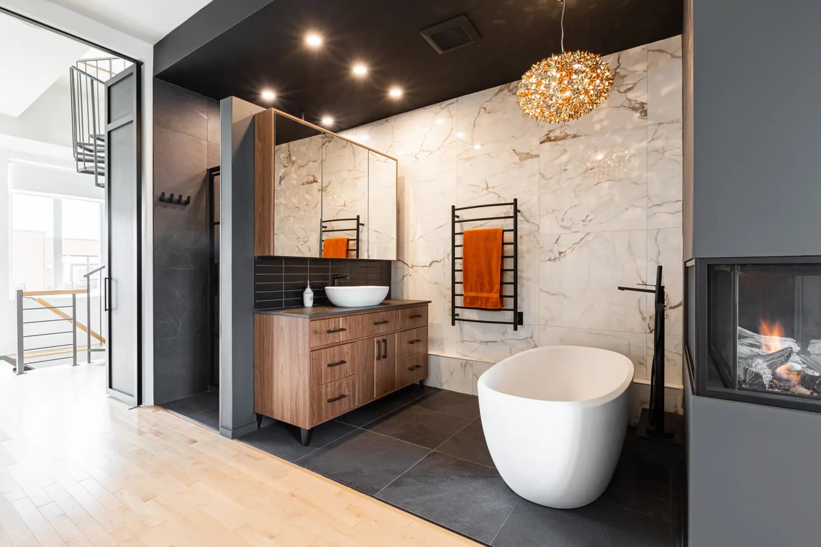 Contemporary bathroom with a freestanding bathtub and walk-in shower, wood flooring, and marble tiles.