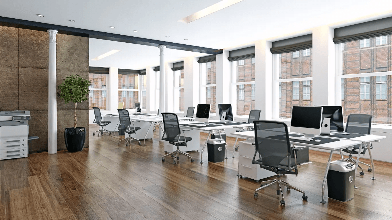 Modern open-plan office with workstations, computers, ergonomic chairs, large windows and wood flooring