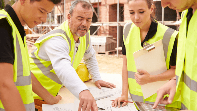 Young apprentices working on a construction site under the supervision of a journeyperson