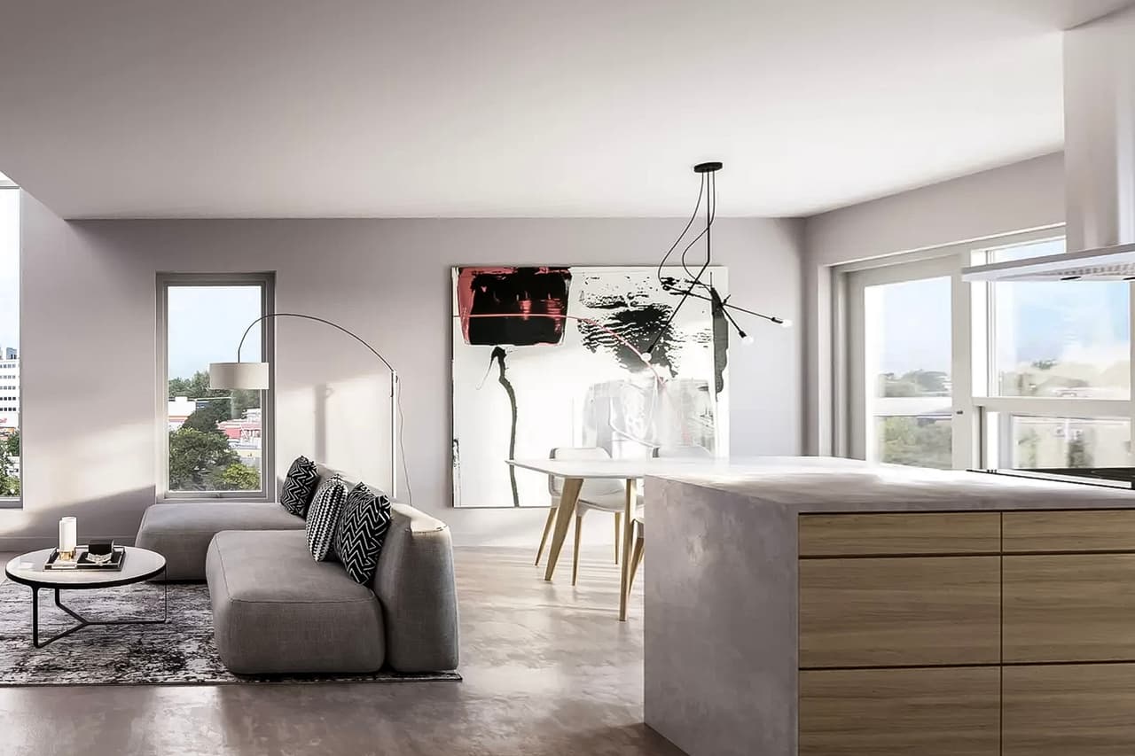 Open-concept living room and kitchen with modern minimalist design, featuring a polished concrete floor, a wood and concrete island, and large windows allowing natural light.