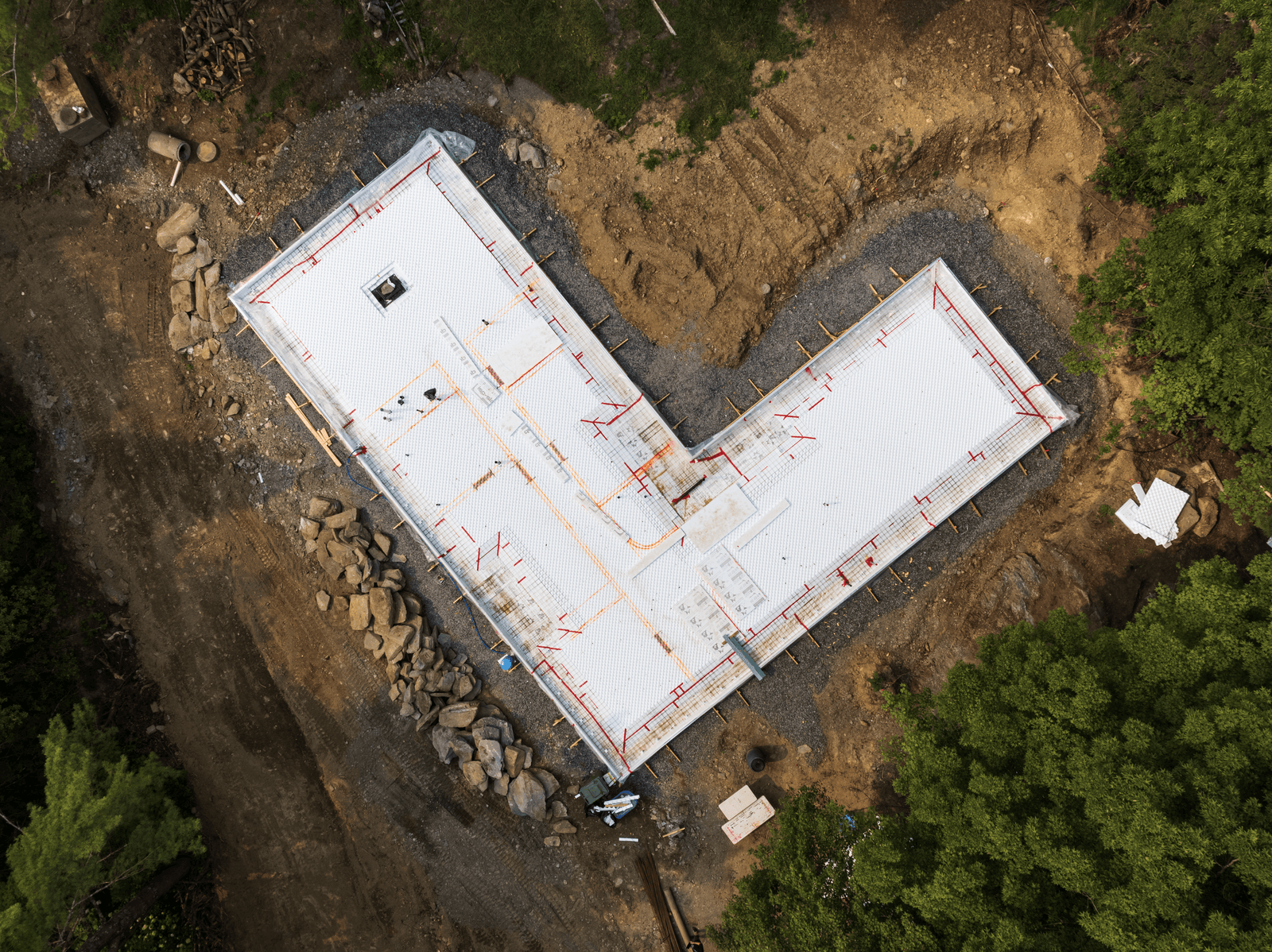 Aerial view of construction site with insulated polystyrene slab and radiant heating pipes being installed