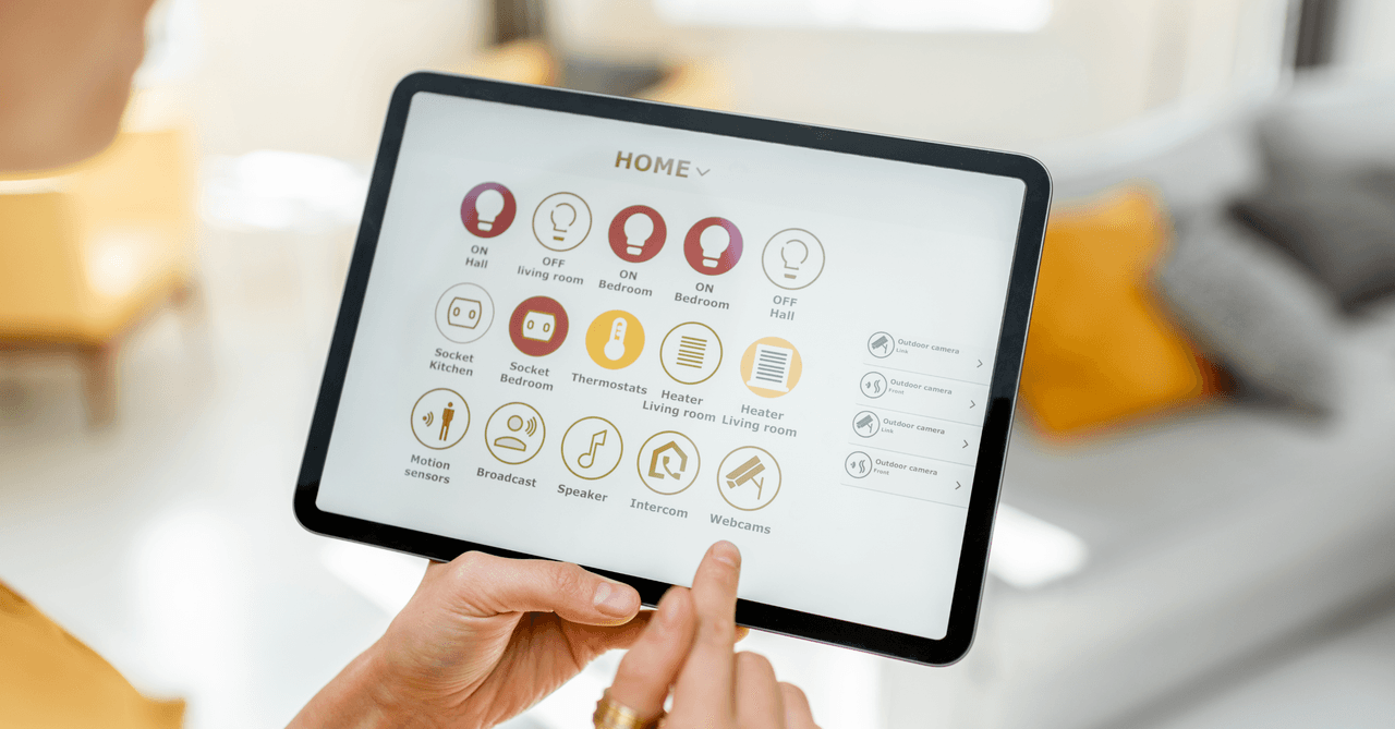 Person using a tablet to adjust smart home controls, lighting, heating, music, etc.