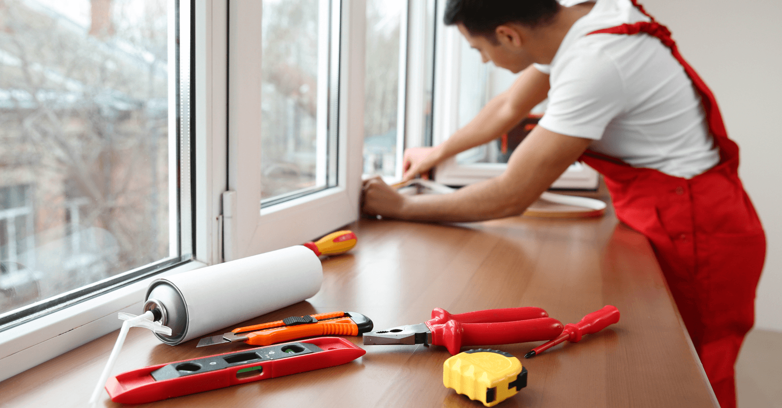 Caulking and PVC window installation by a professional with hand tools