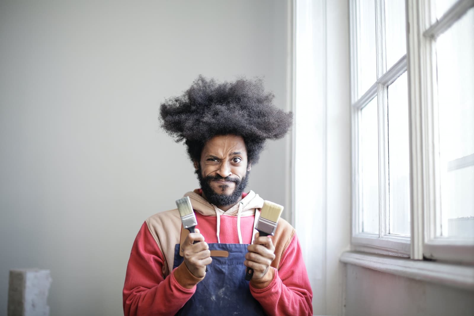 Man holding two paintbrushes